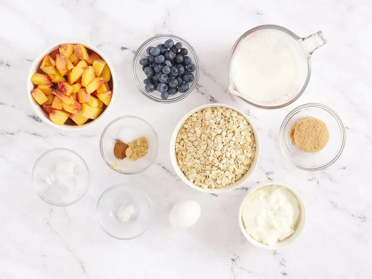Zutaten f&uuml;r ein leckeres Fr&uuml;hst&uuml;ck: Haferflocken, Pfirsiche, Blaubeeren, Joghurt, Milch, Zucker, Zimt und ein Ei. Man kann Haferflocken roh essen!