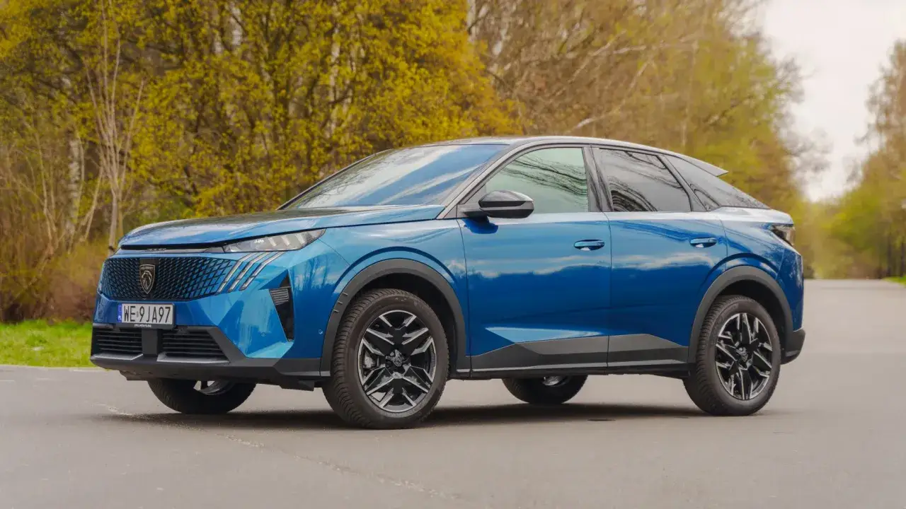 Błękitny Peugeot 3008 hybryda na tle wiosennej zieleni. Nowoczesny design i dynamiczna sylwetka.
