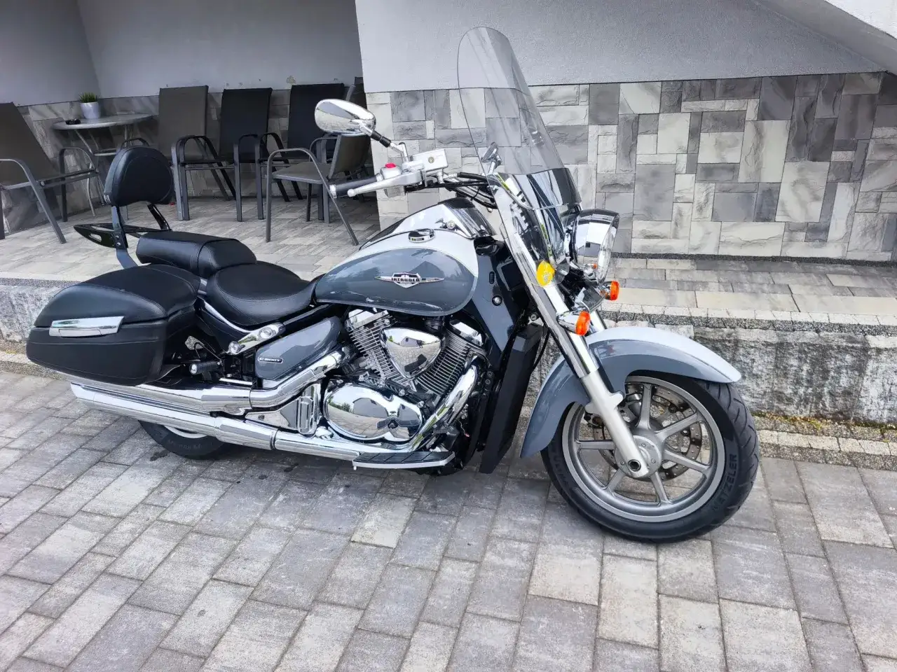 Szary Suzuki Intruder 1400 z kuframi i dużą szybą. Klasyk, który ma swoje wady i zalety.