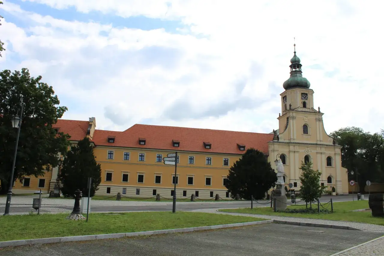 Opactwo cystersów w Rudach z charakterystyczną wieżą i żółtym budynkiem klasztornym.