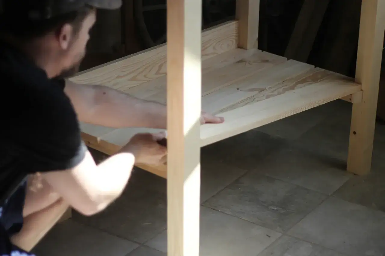 Mężczyzna składa blat stołu z kantówek. Prosty projekt, jak zrobić stół z kantówek.