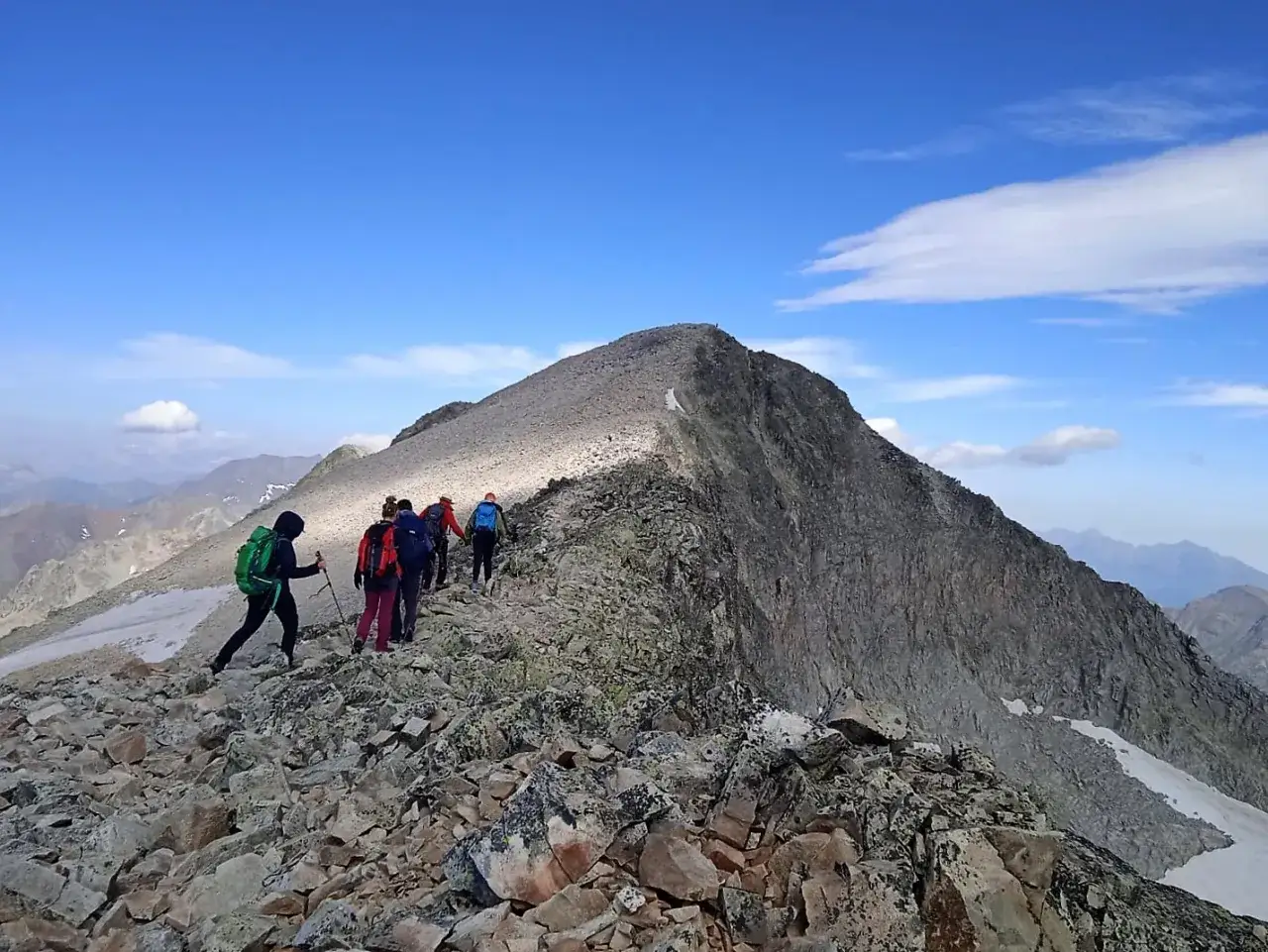 Grupo de excursionistas en una cresta rocosa, un ejemplo de monta&ntilde;ismo. El senderismo es m&aacute;s accesible, pero esto es monta&ntilde;ismo.