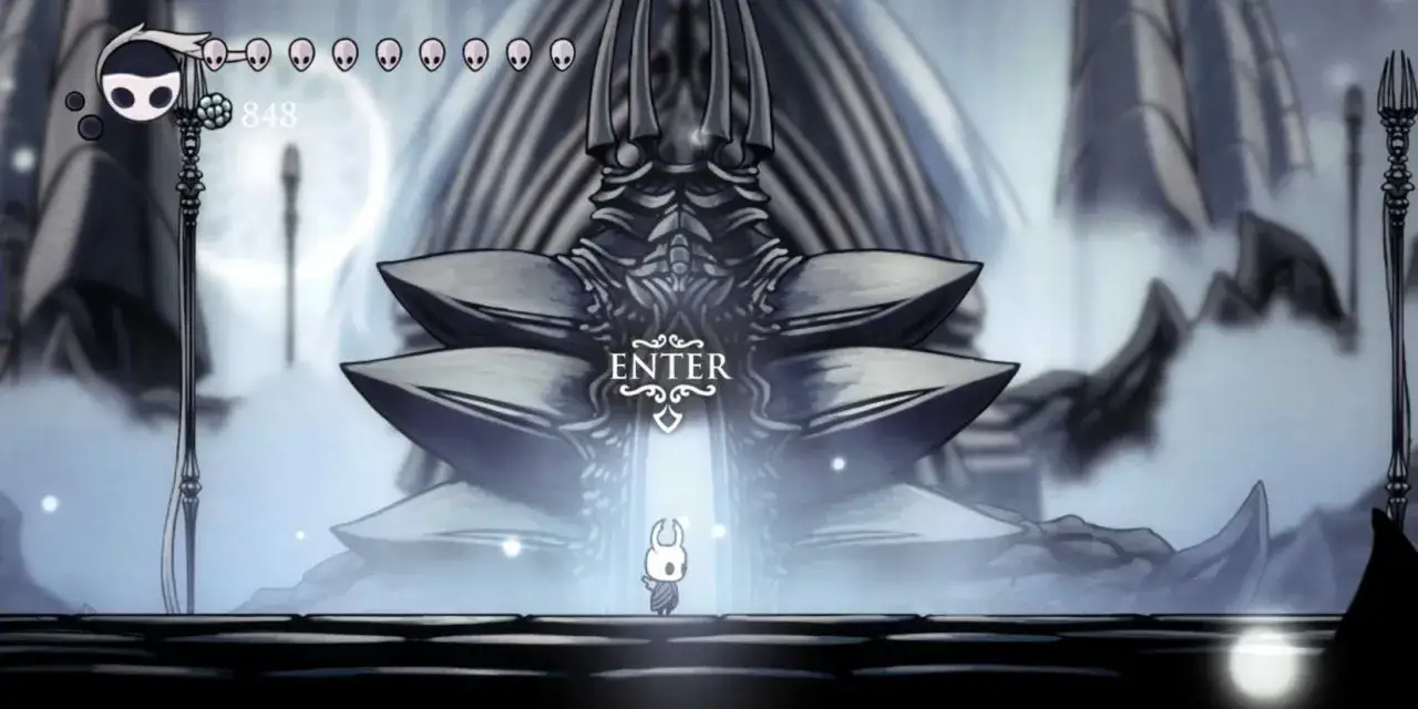Mały rycerz stoi przed wejściem do Białego Pałacu w Hollow Knight.