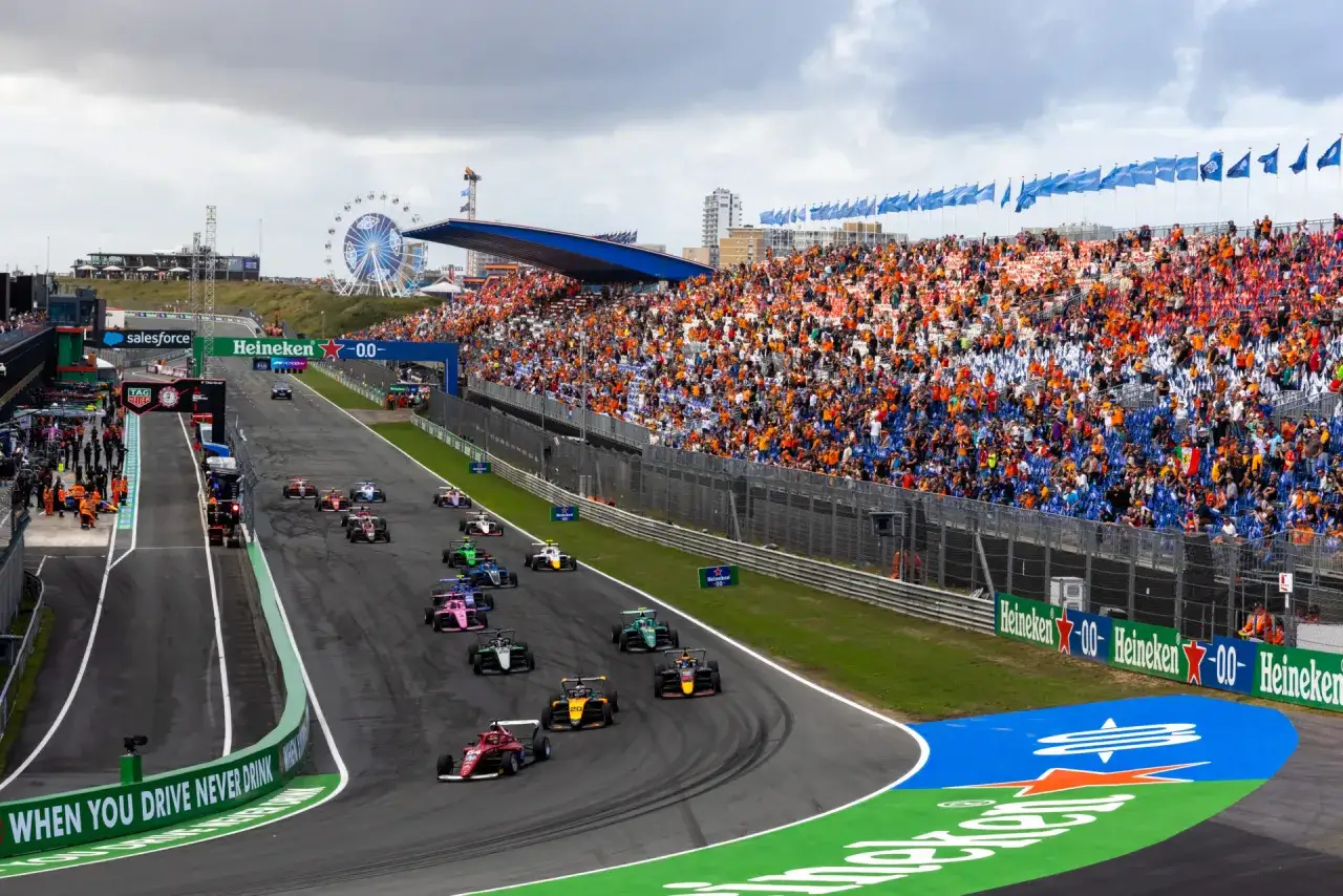 Coches de carreras compiten en el Dutch Grand Prix, con gradas repletas de aficionados.