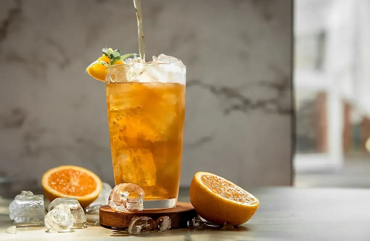 Orzeźwiający drink z lodem i pomarańczą. Zastanawiasz się, dlaczego lód w kostkarce domowej szybciej rozwadnia drinka?