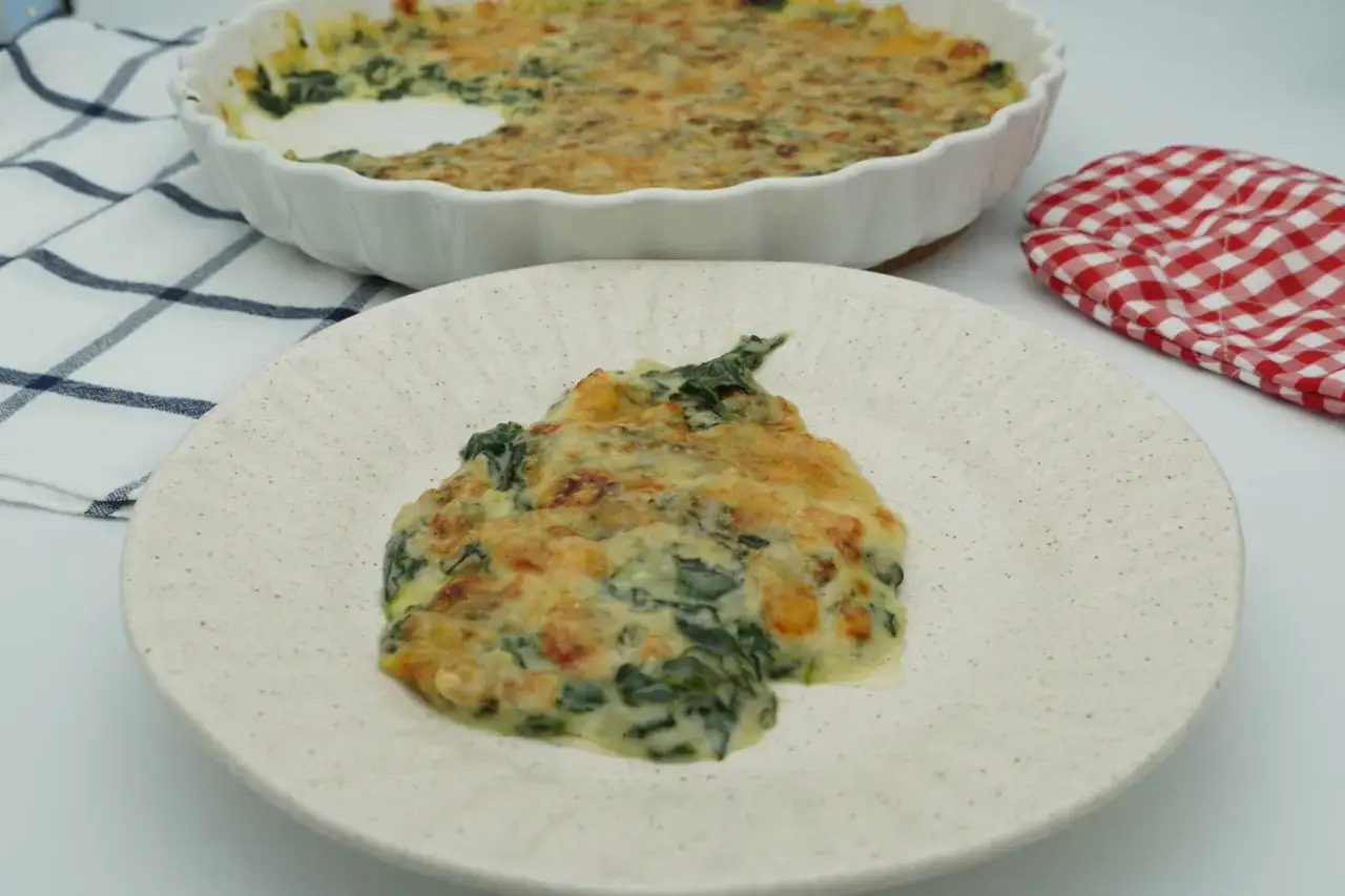 Un plato de espinacas con bechamel gratinada, cremoso y dorado, listo para disfrutar.