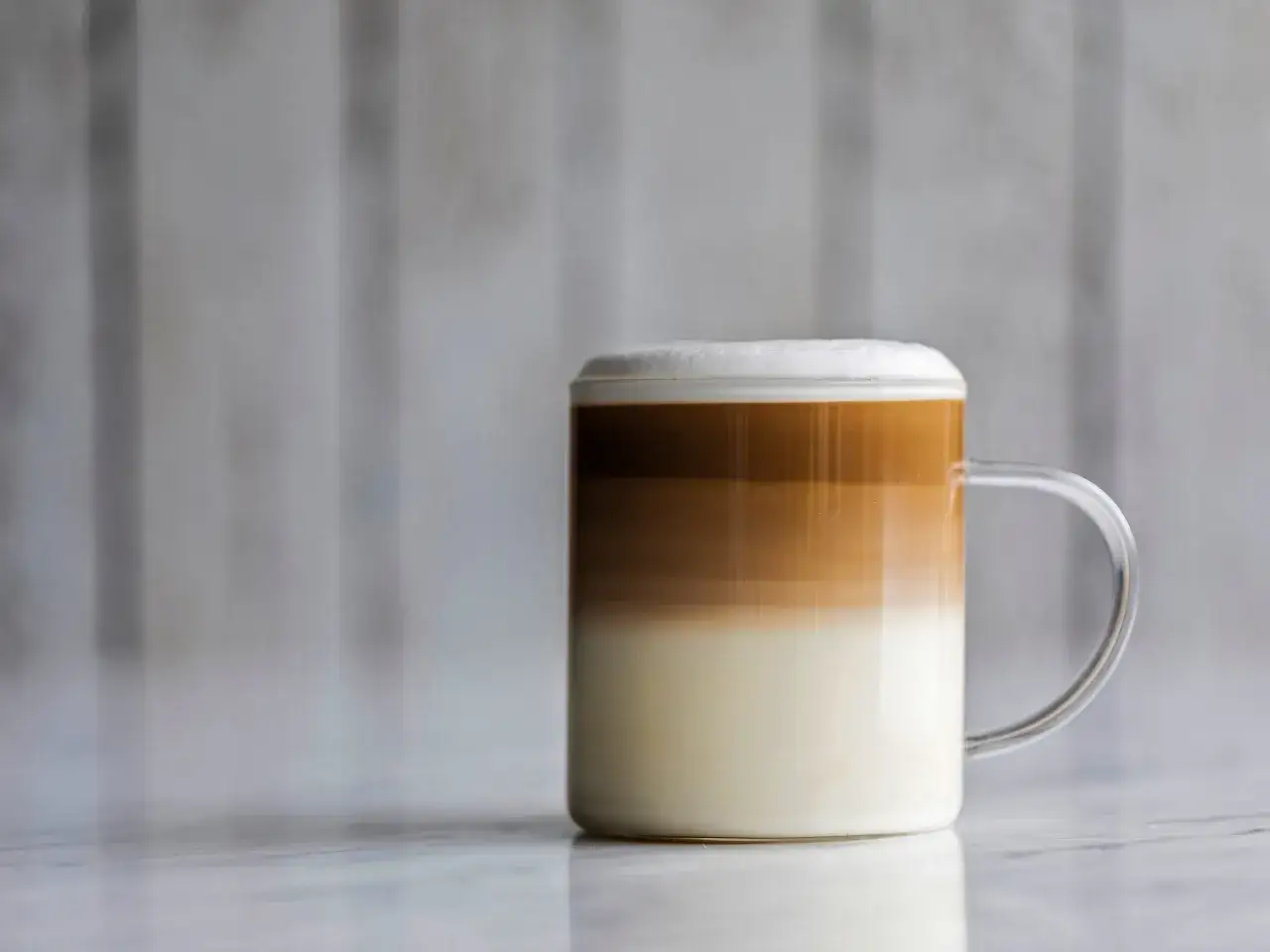 Warstwowy napój kawowy w szklance, idealny, by dowiedzieć się, jak zrobić latte macchiato.