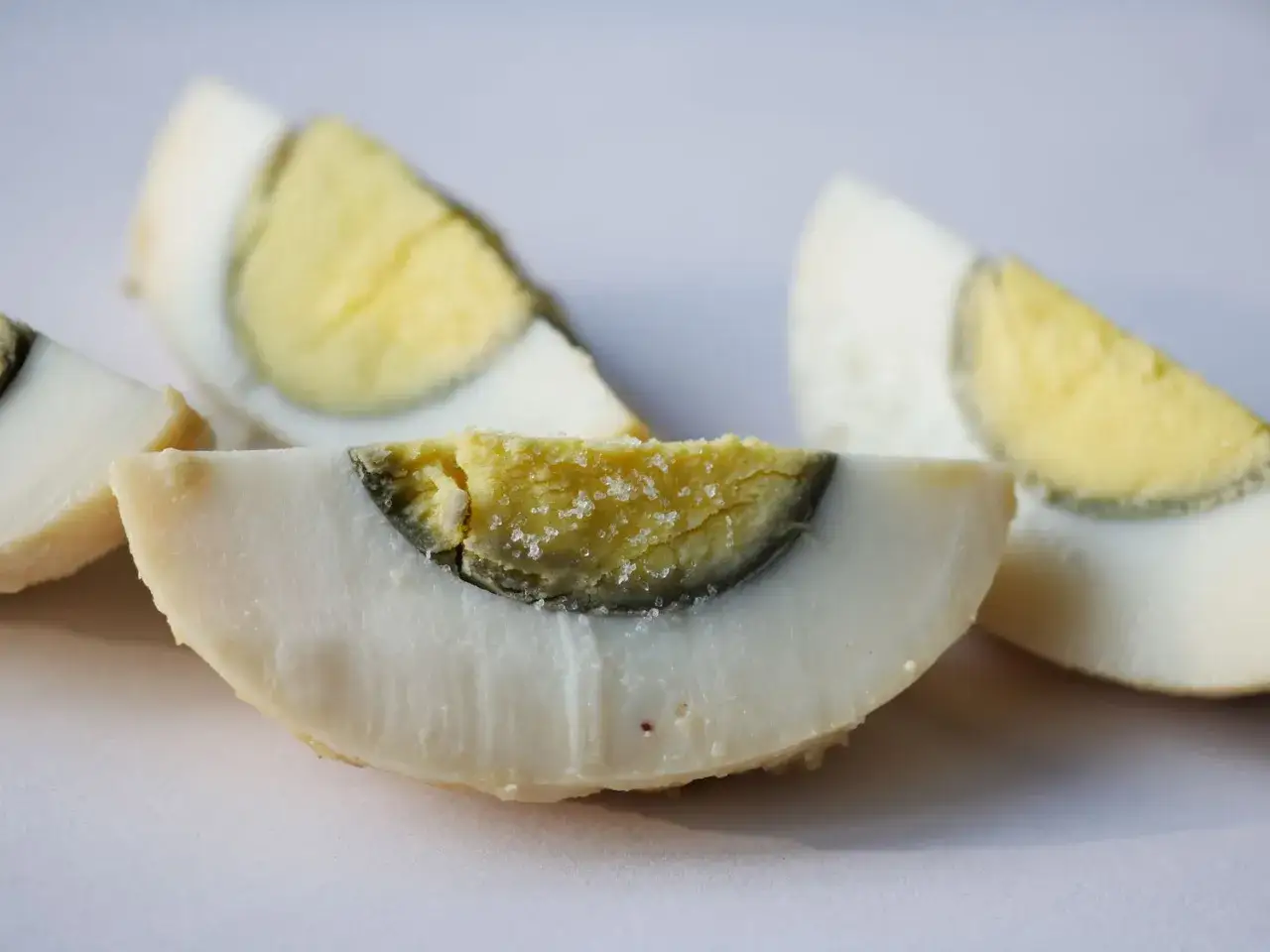 Tranches d'oeuf dur, dont le jaune a une l&eacute;g&egrave;re teinte verd&acirc;tre, parsem&eacute;es de sel.