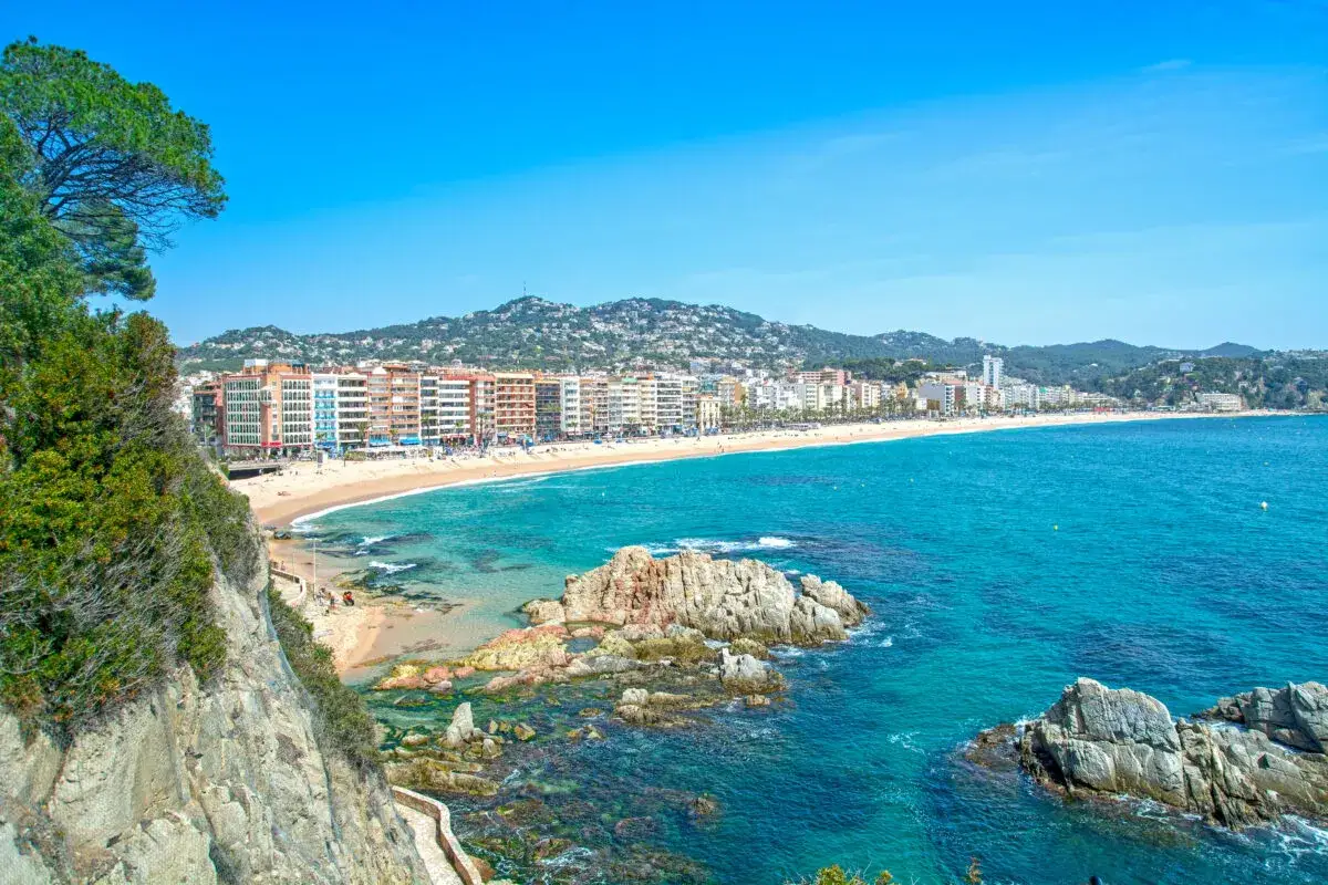 Widok na Lloret de Mar z klifu. Piękna plaża, turkusowe morze i zabudowania w tle. Idealne miejsce na wakacje, niedaleko lotniska.