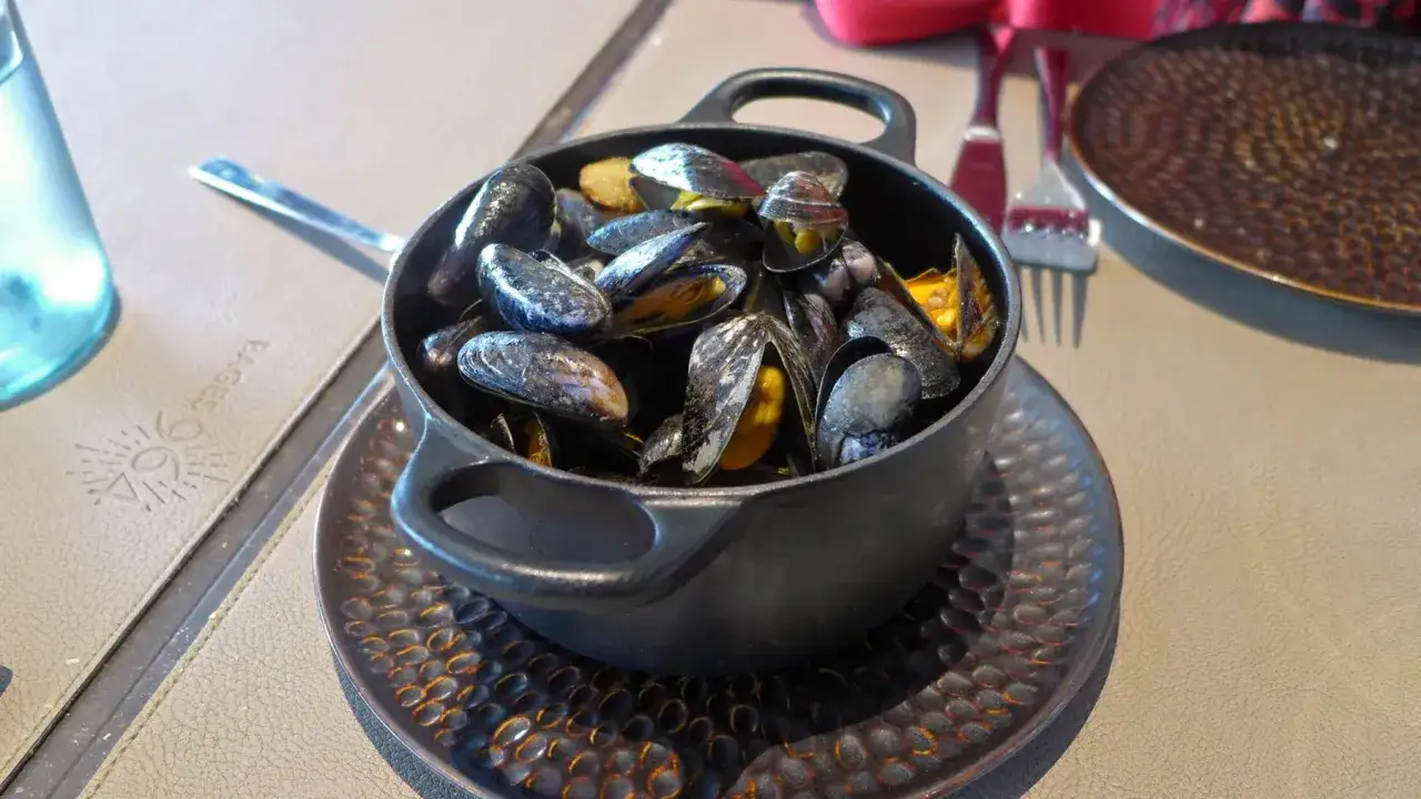 Un cuenco lleno de mejillones al vapor, listos para ser disfrutados.