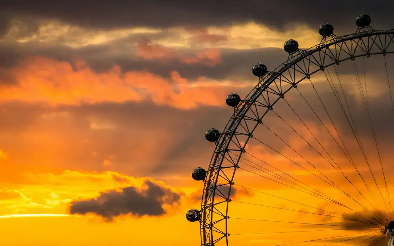 Zach&oacute;d słońca nad Londynem, a na pierwszym planie fragment London Eye. Ciekawe, czy widać stąd wszystkie 32 kapsuły?