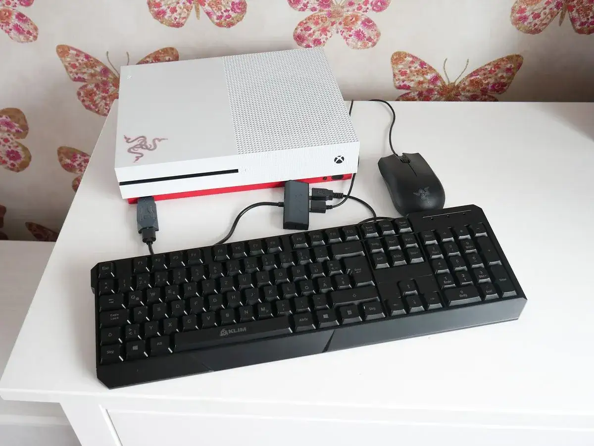 Xbox mit Maus und Tastatur für präzises Gaming. Die Konsole ist weiß mit rotem Akzent.