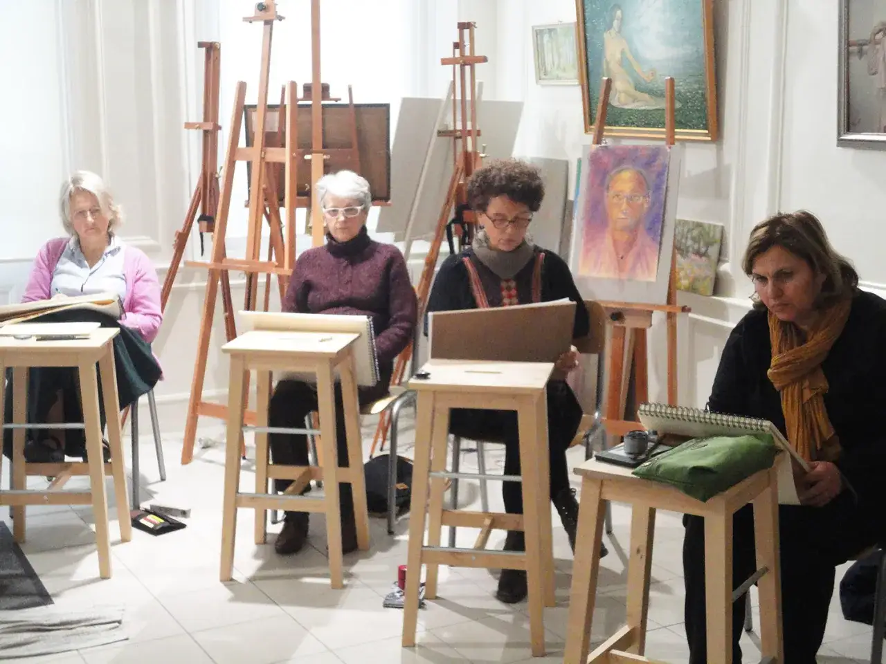 Des artistes dessinent des modèles vivants pour peintres dans un atelier.
