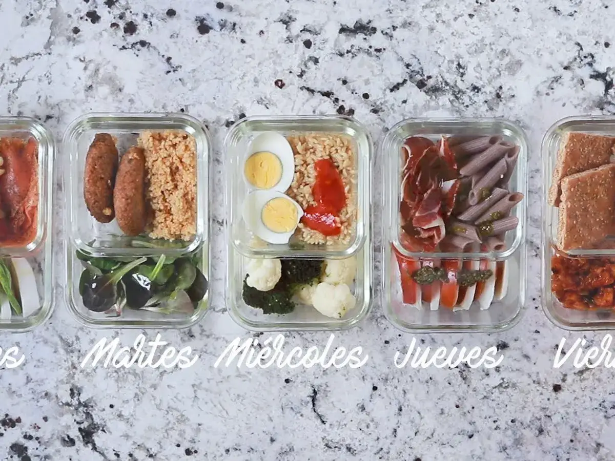 Comidas para llevar al trabajo en tupper: salmón, salchichas con cuscús, arroz con huevo y verduras, pasta con jamón y pan con guiso.