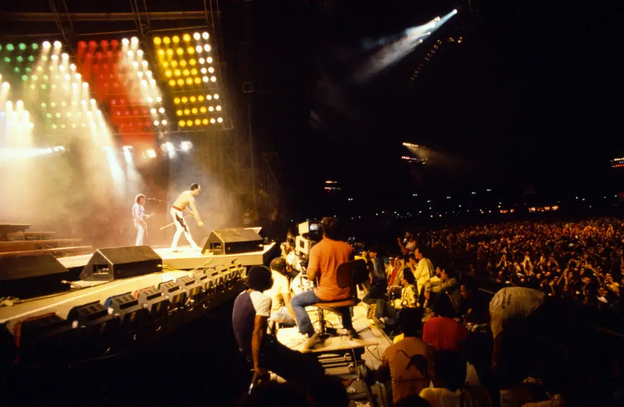Koncert Queen w Polsce. Freddie Mercury i Brian May na scenie, tłum szaleje.