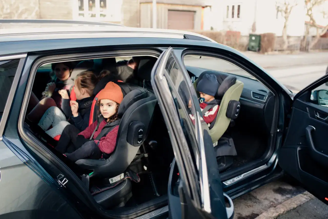 Niños en sillas de coche, listos para salir. Es hora de saber cuando pasar bebe a silla de coche.