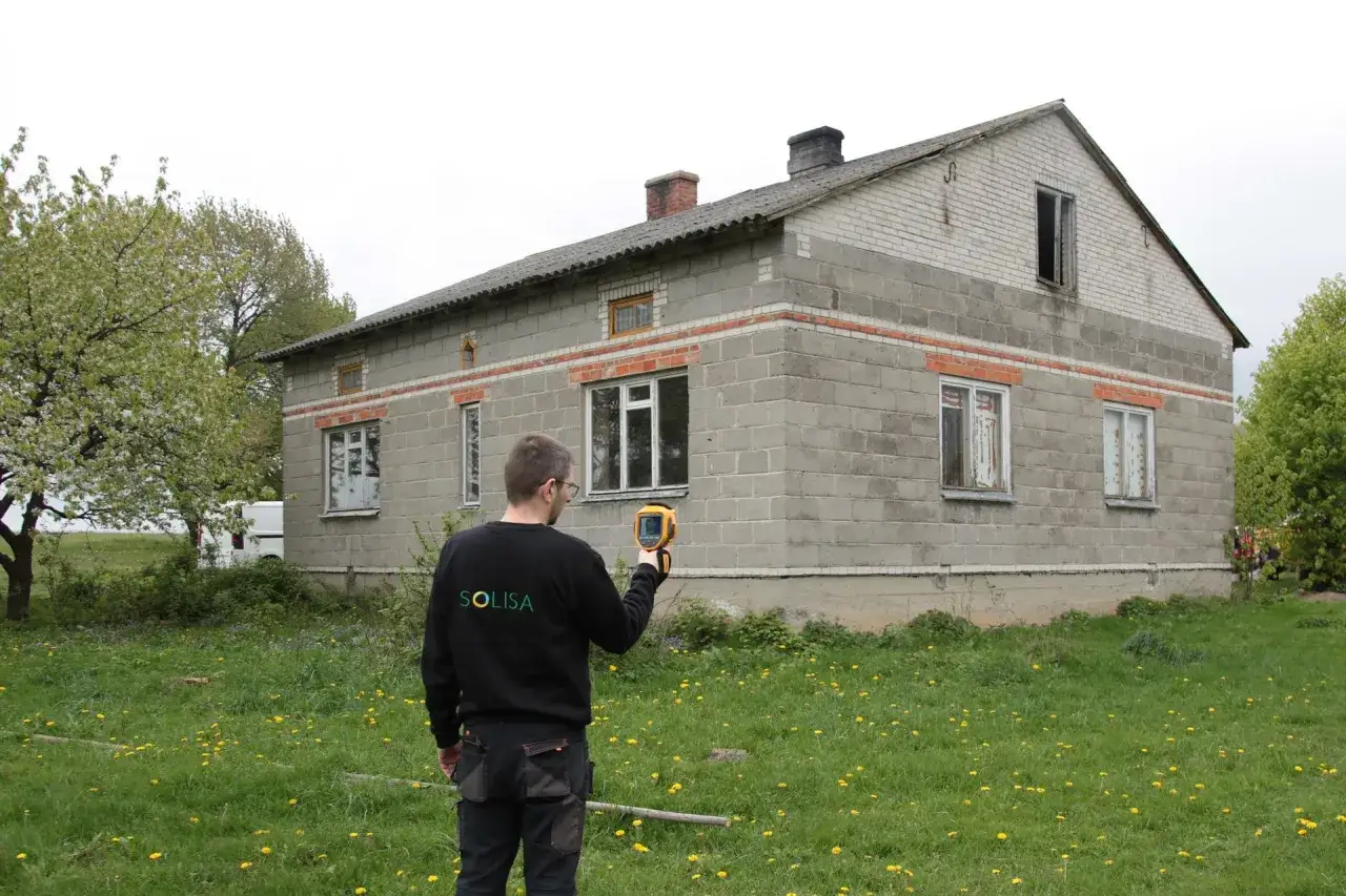 Specjalista sprawdza budynek pod kątem montażu pompy ciepła do starej instalacji.