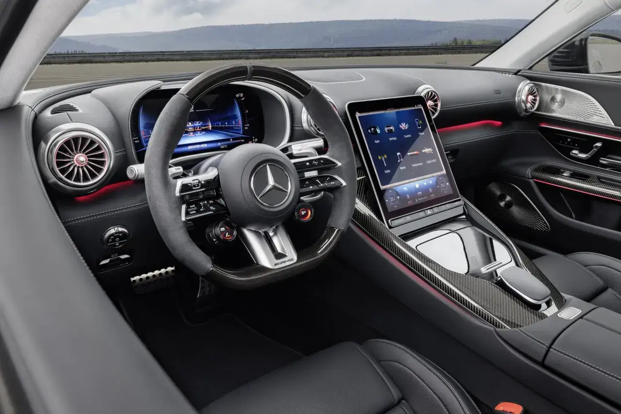Wnętrze Mercedes-AMG GT 63: cyfrowy kokpit, sportowa kierownica AMG, ekran dotykowy i czerwone podświetlenie tworzą futurystyczny klimat.