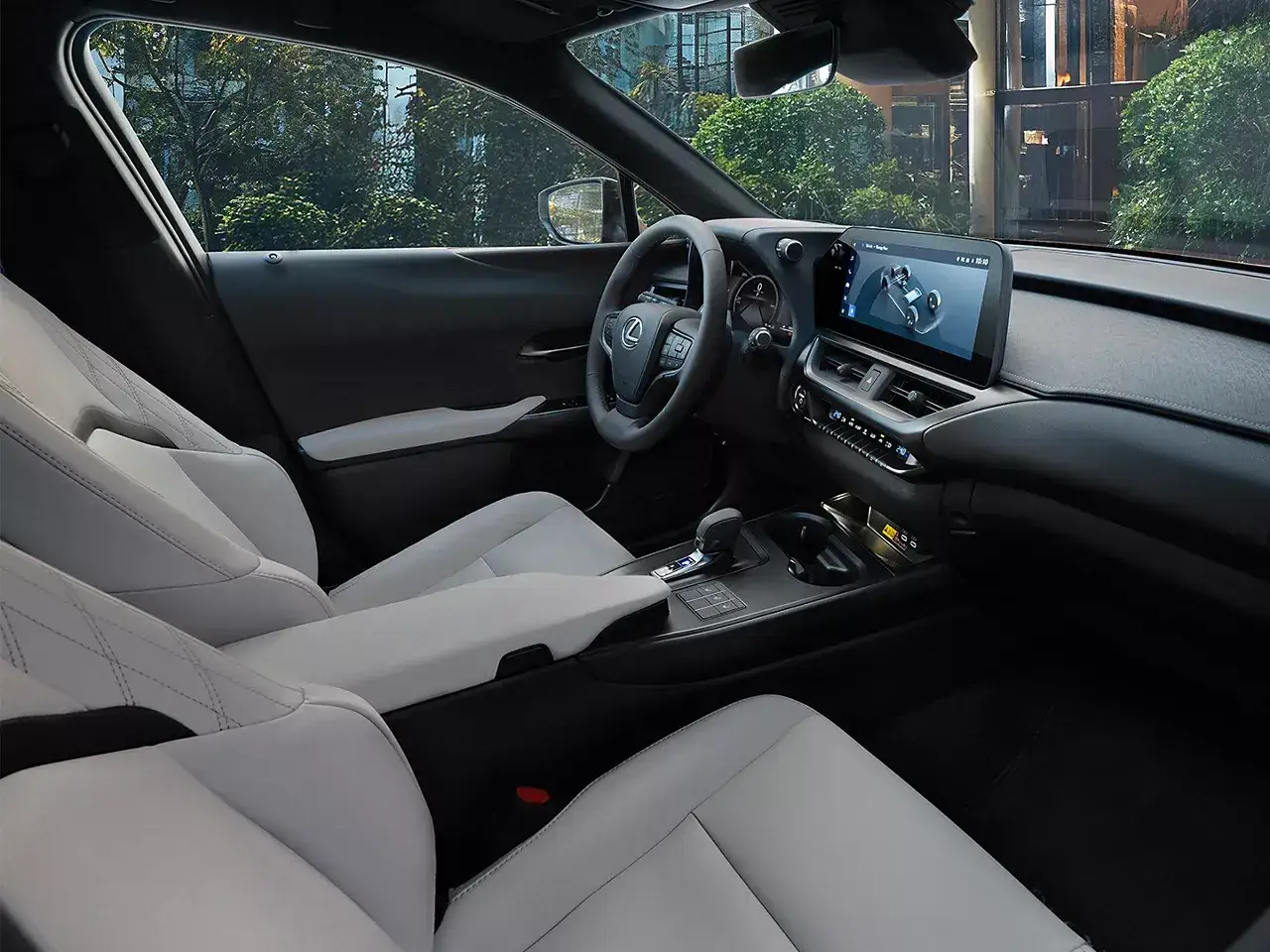 Wnętrze Lexus UX 300h z jasnymi, pikowanymi fotelami i nowoczesnym ekranem multimedialnym.