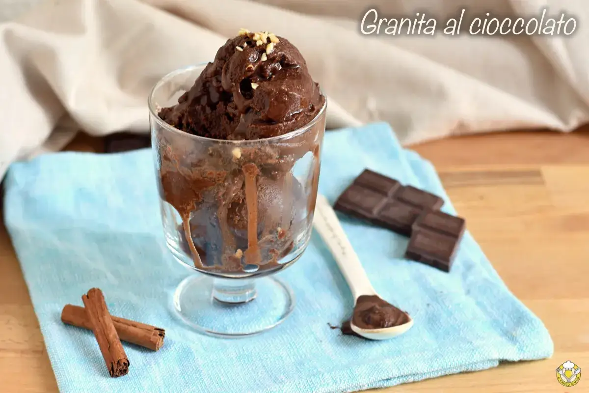 Coppa di granita al cioccolato, con pezzi di cioccolato e cannella a lato.