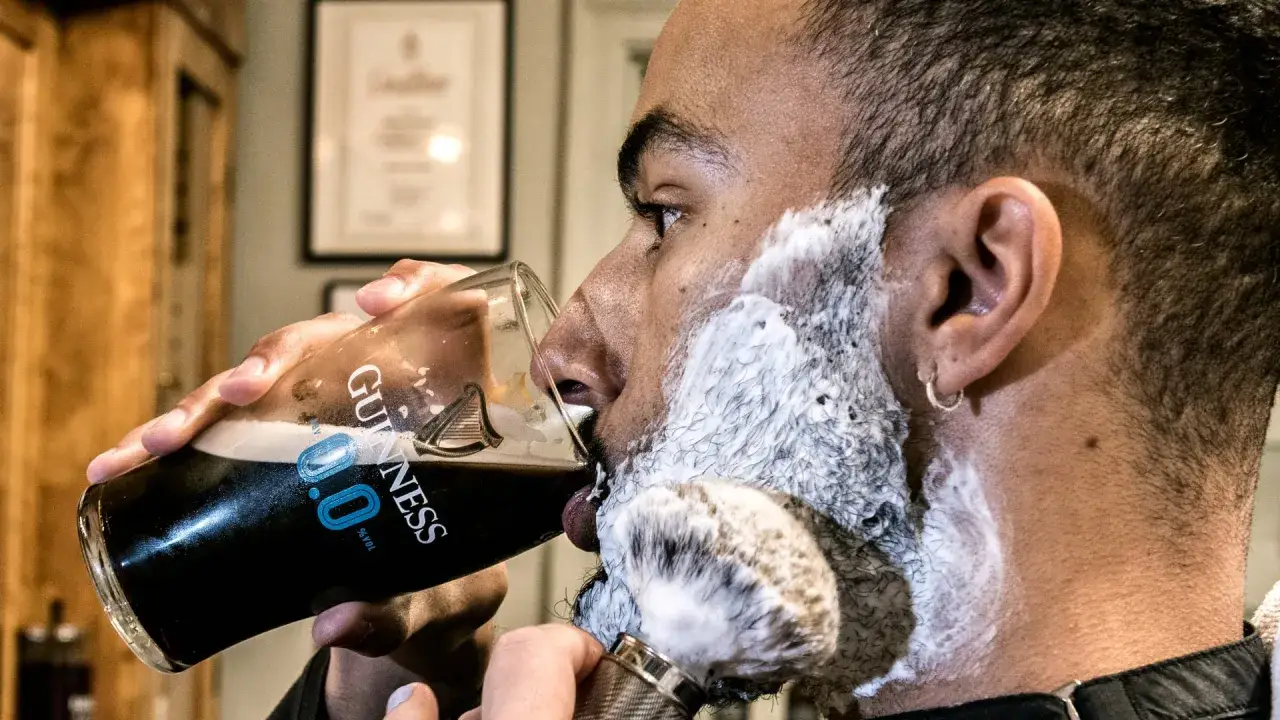 Man med l&ouml;dder och rakborste dricker Guinness. En perfekt start p&aring; en november mustasch.
