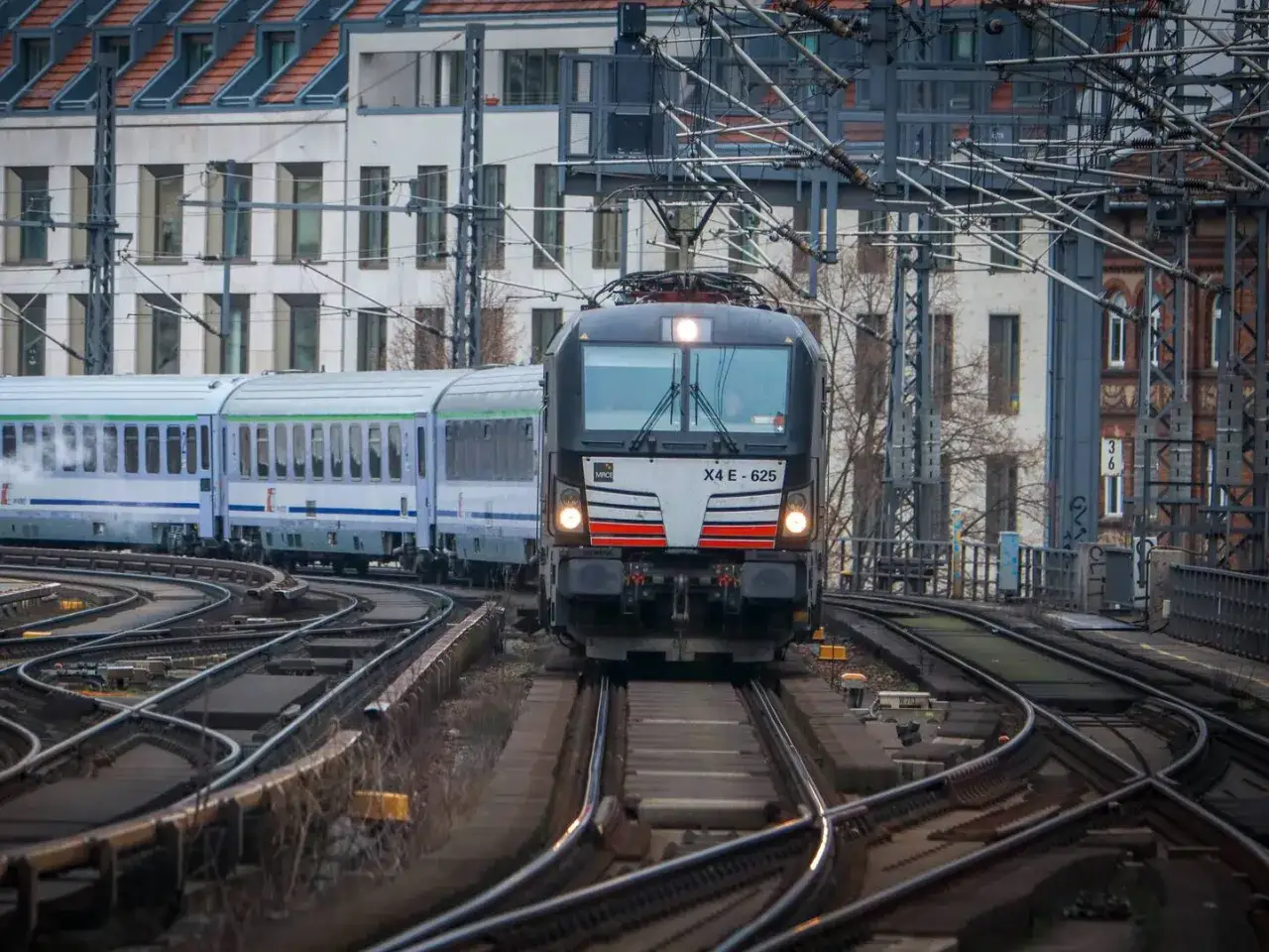 Ein Zug f&auml;hrt auf verschlungenen Gleisen. Die Reise von Dresden nach Polen beginnt hier, mit modernen Waggons und einer starken Lokomotive.