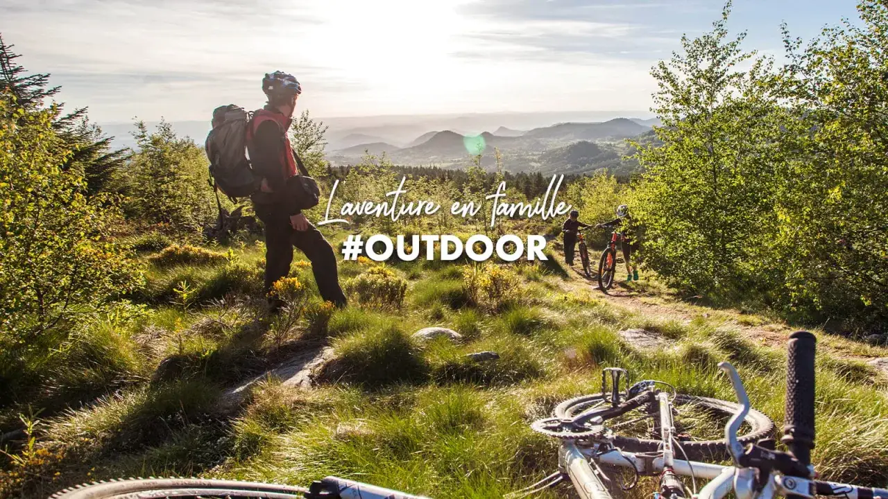 Famille en VTT dans les paysages verdoyants des destinations Rhône-Alpes. L'aventure #OUTDOOR commence ici.