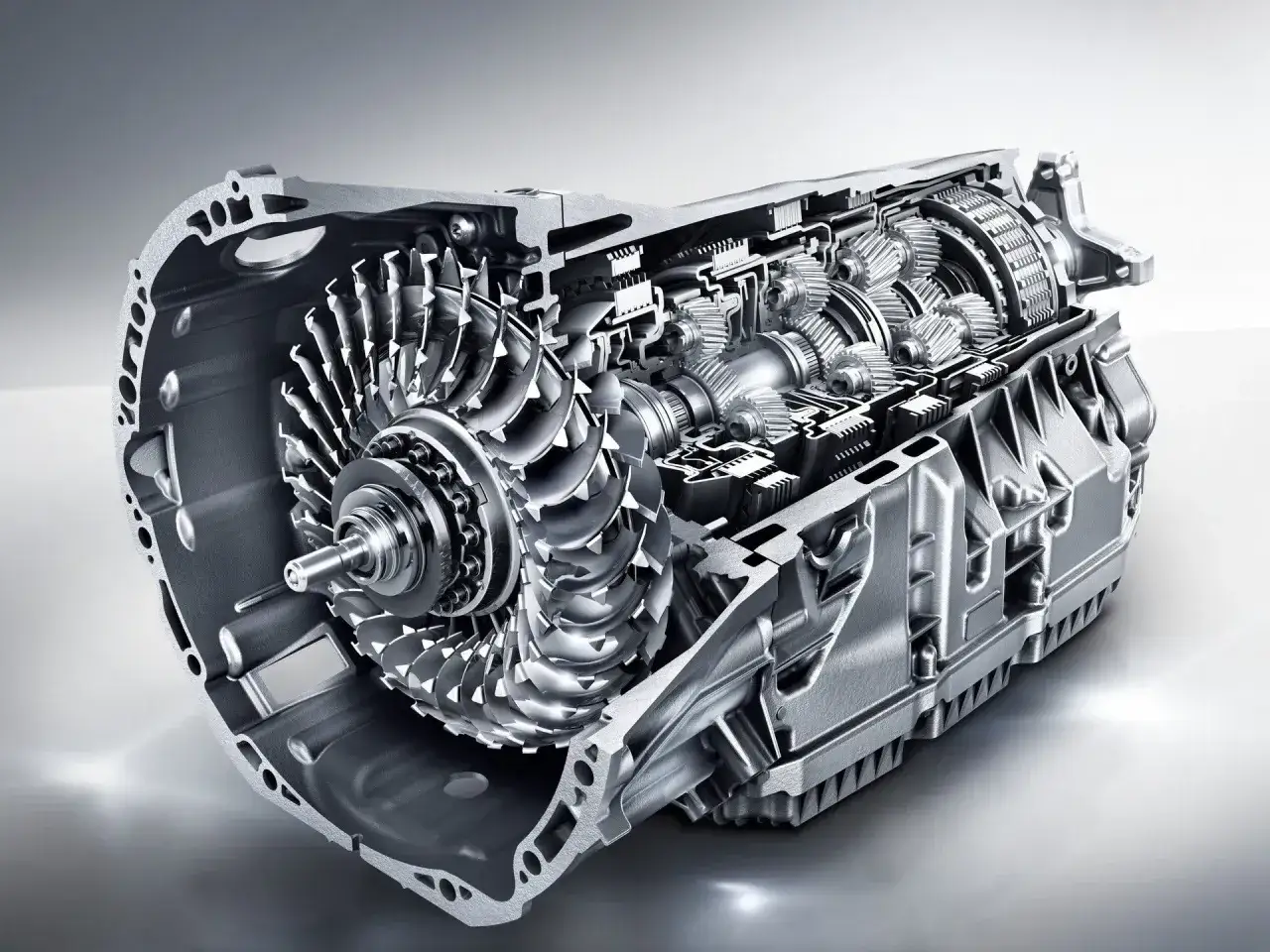Przekrój skrzyni biegów CVT z widocznym kołem pasowym i elementami hydraulicznymi.