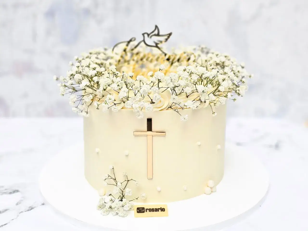 Elegancki tort komunijny ozdobiony gipsówką, złotym krzyżem i gołębicą. Jedne z najpiękniejszych tortów komunijnych.