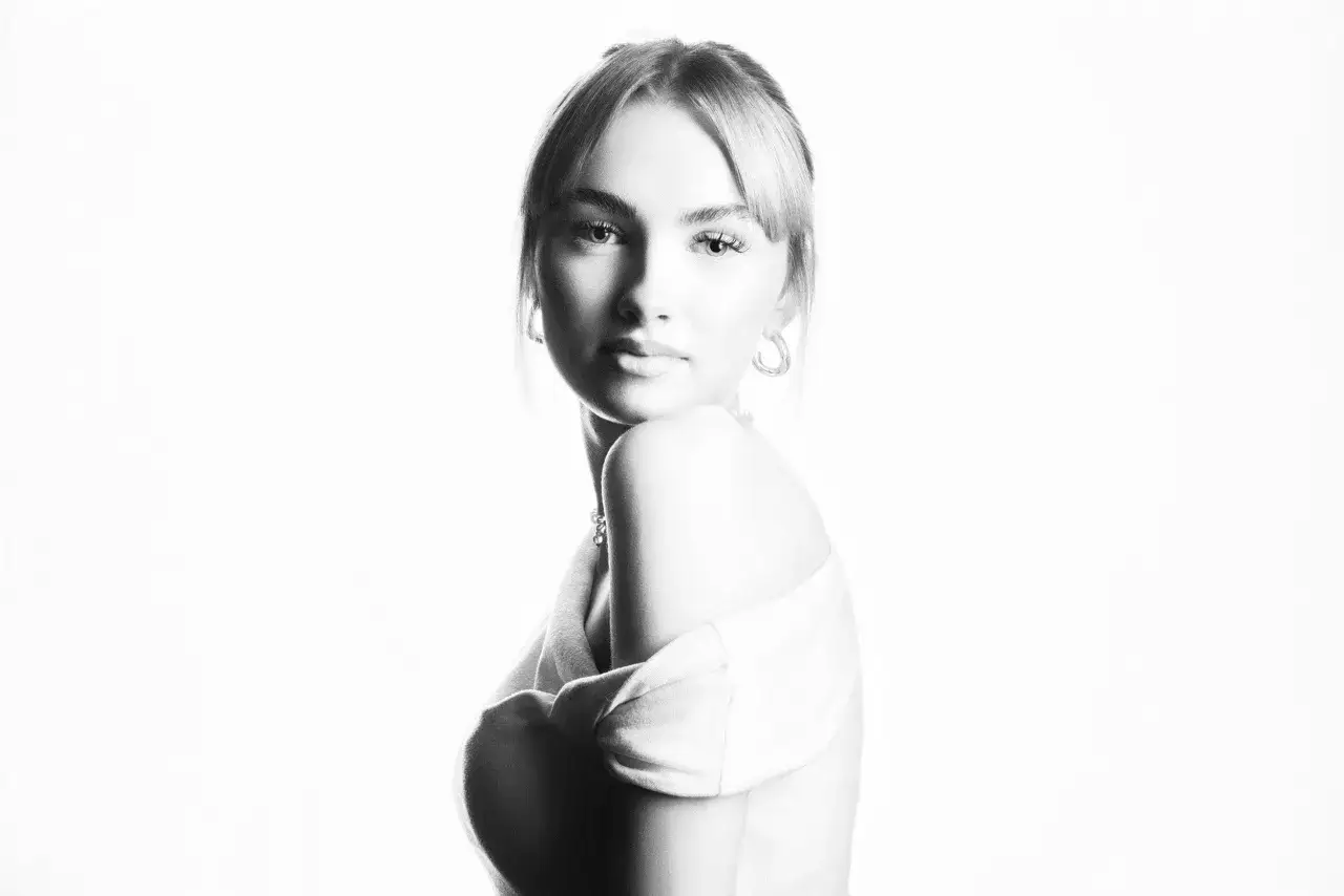 Portret młodej kobiety w stylu high key fotografia. Delikatne światło podkreśla jej rysy, tworząc eteryczny nastrój.