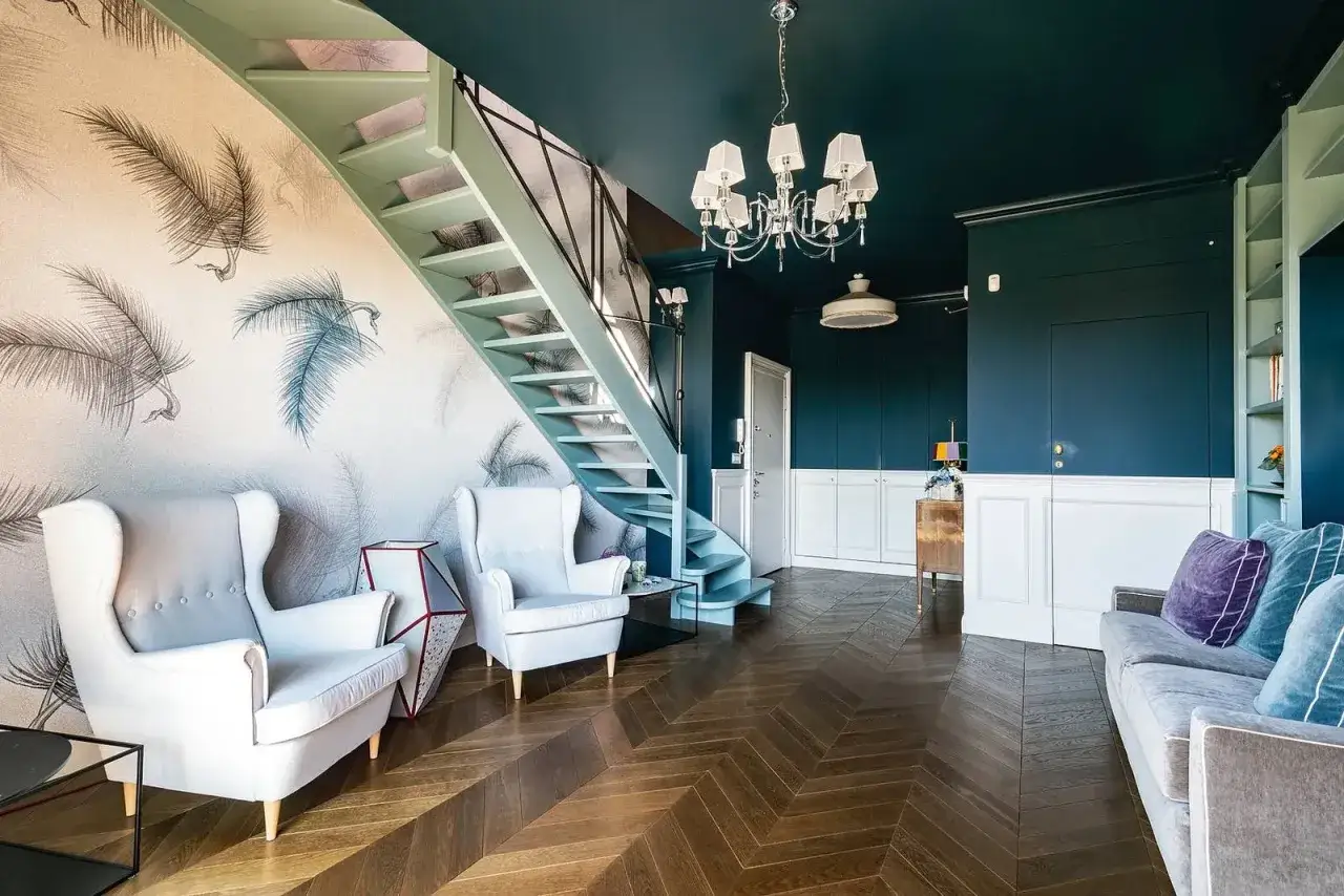 Soggiorno moderno con scala, divani bianchi e parquet a spina di pesce. Un esempio di come le case ristrutturate possono diventare spazi di design.
