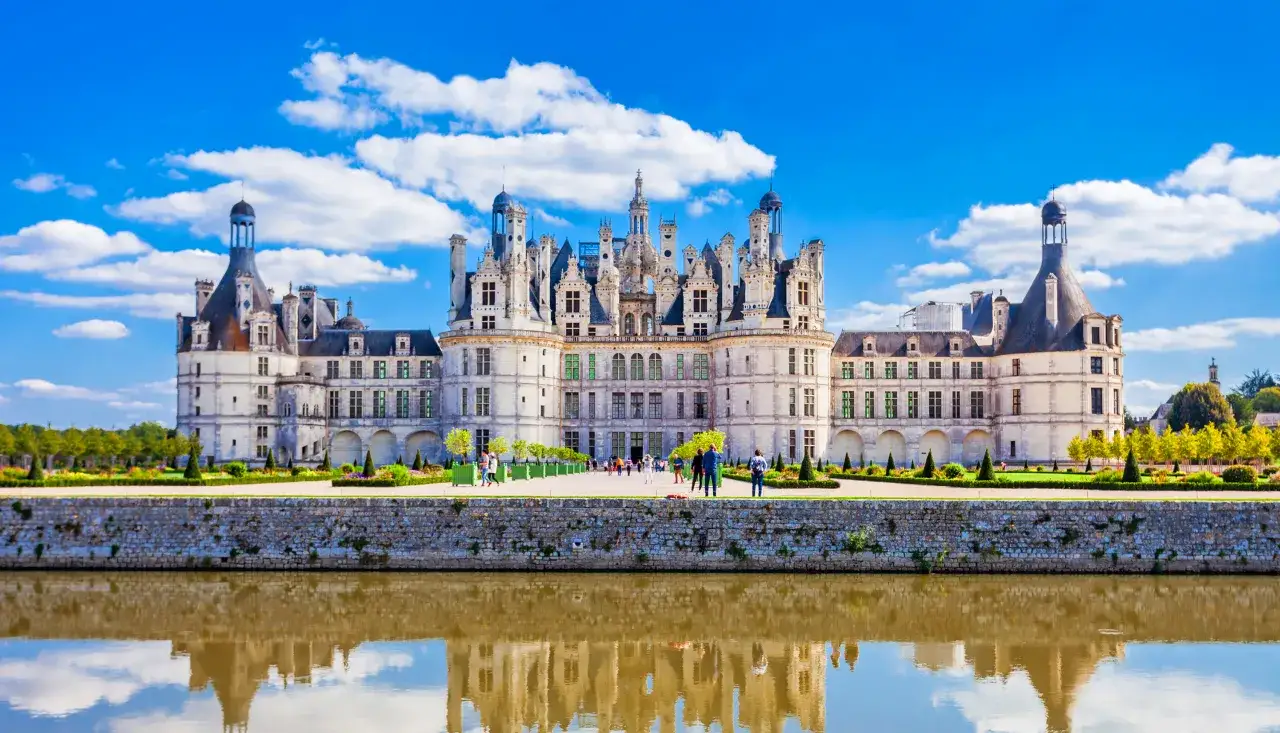 Zamek Chambord nad wodami Loary, najdłuższej rzeki Francji, odbija się w spokojnej tafli.