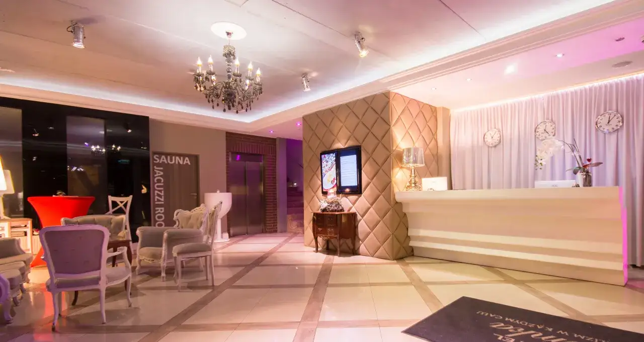 Eleganckie wnętrze hotelu Ramka Poznań: recepcja, fotele, żyrandol i zegary.