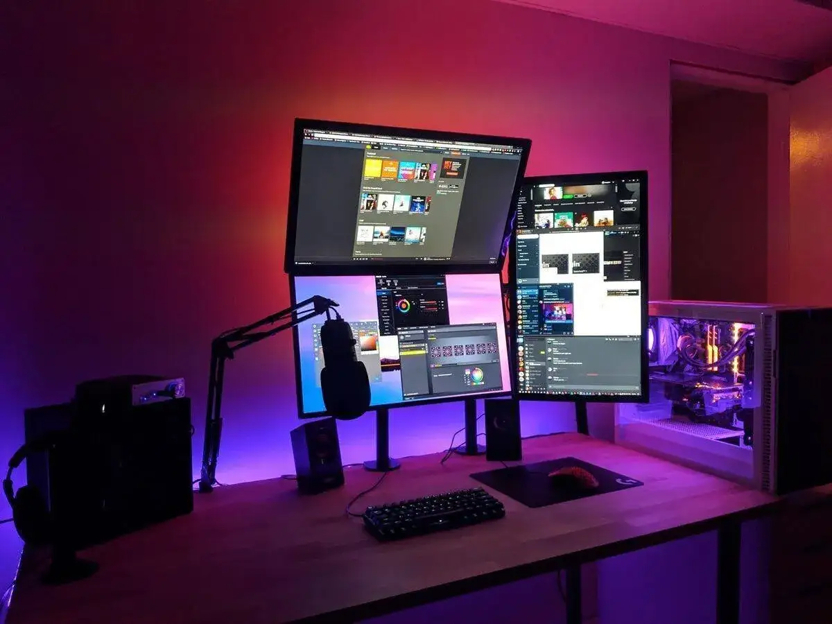 A streamer's dream setup: multiple monitors, a boom mic, and RGB lighting. Great tips for streaming are visible on screen.