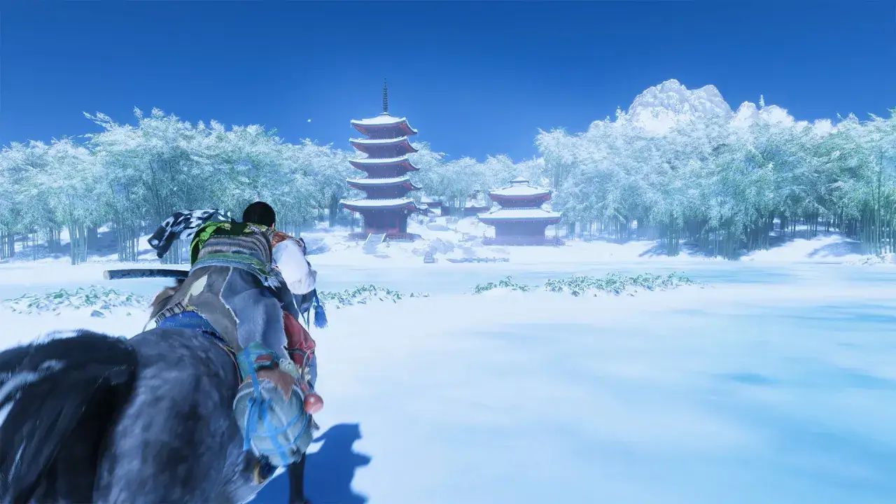 Samuraj na koniu przemierza zimowy krajobraz. W oddali widać pagody i ośnieżone drzewa. Gra Ghost of Tsushima wymaga pięknej grafiki.