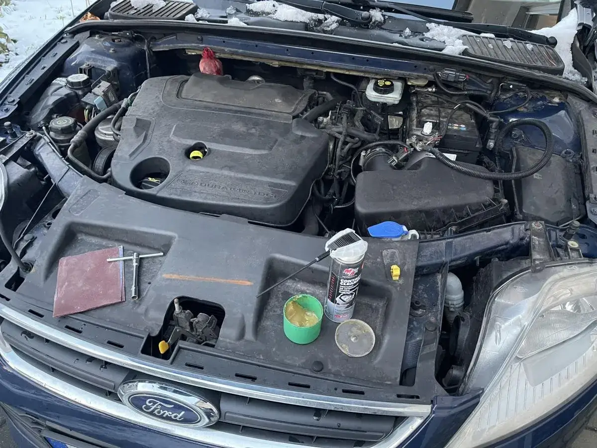 Silnik Ford Mondeo MK4 nie odpala. Na masce leżą narzędzia i preparaty do czyszczenia.