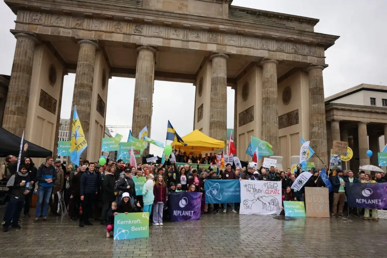 Protest pod Bramą Brandenburską. Ludzie z flagami i transparentami, m.in.