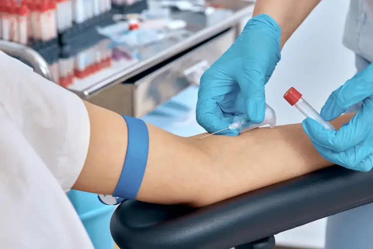 Pobieranie krwi do badania, kt&oacute;re może być częścią diagnostyki krzywej cukrowej. Rękawiczki medyczne, igła i prob&oacute;wka.