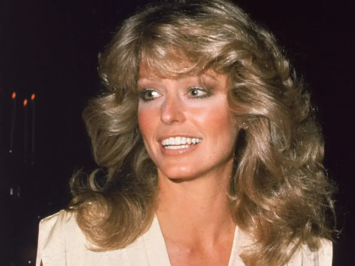 Ikona lat 80. w modzie damskiej, z burzą blond włosów i promiennym uśmiechem.