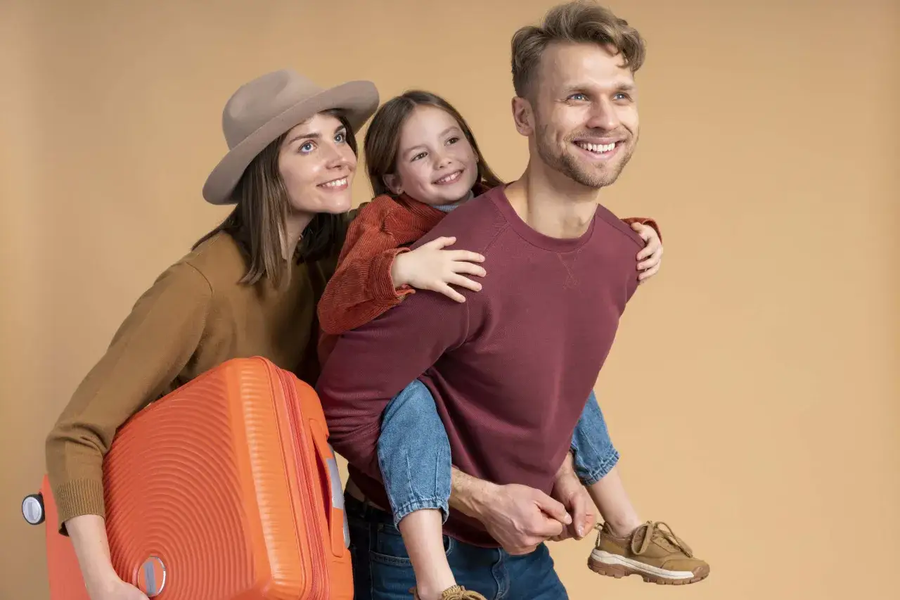 Familia feliz prepar&aacute;ndose para viajes inolvidables para ni&ntilde;os. Padre lleva a su hija a caballito, madre con maleta.