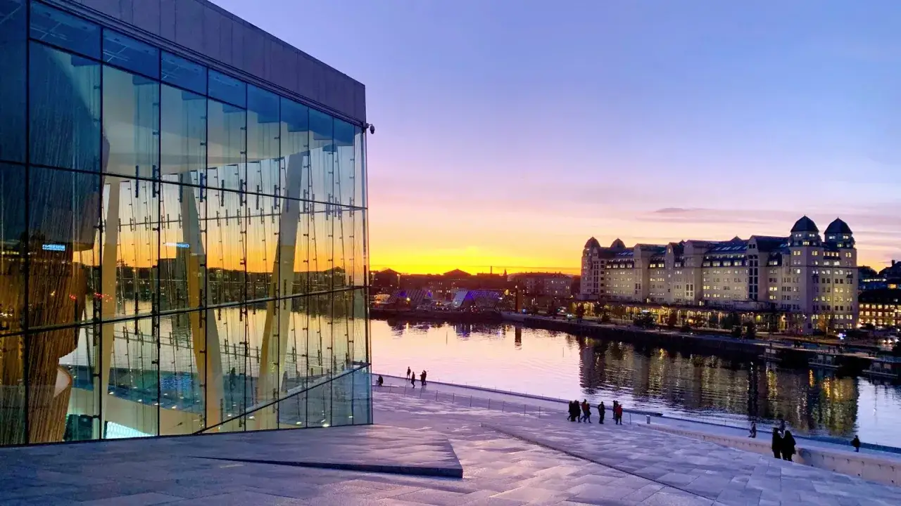 Solnedg&aring;ng &ouml;ver Oslo centrum med Operahuset i f&ouml;rgrunden och en vacker himmel.