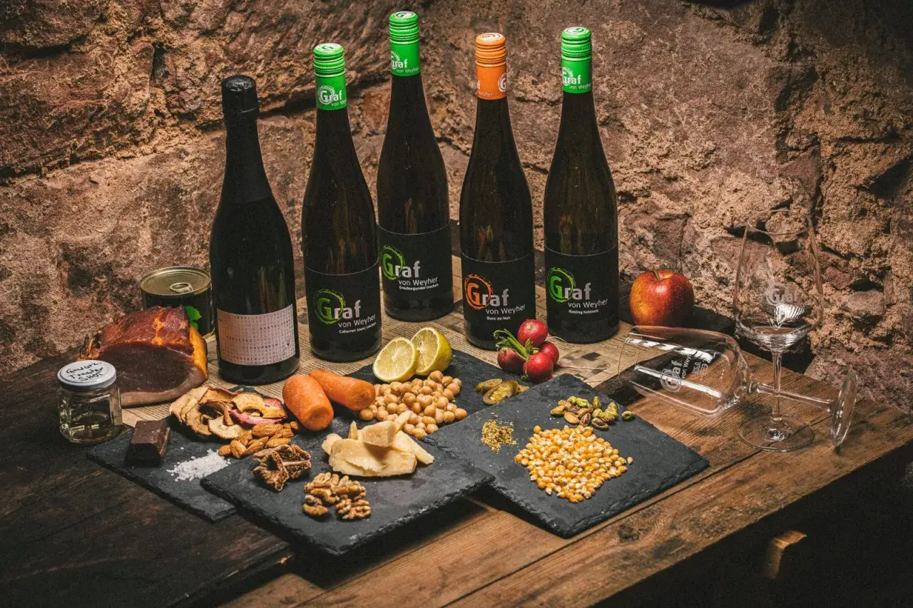 Flaschen mit Wein, Fleisch, Gem&uuml;se und N&uuml;ssen &ndash; die perfekte Auswahl, welcher Rotwein zum Wild kochen passt.