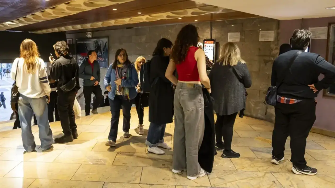 Gente esperando en la entrada de un cine, quizás para la fiesta del cine Zaragoza.