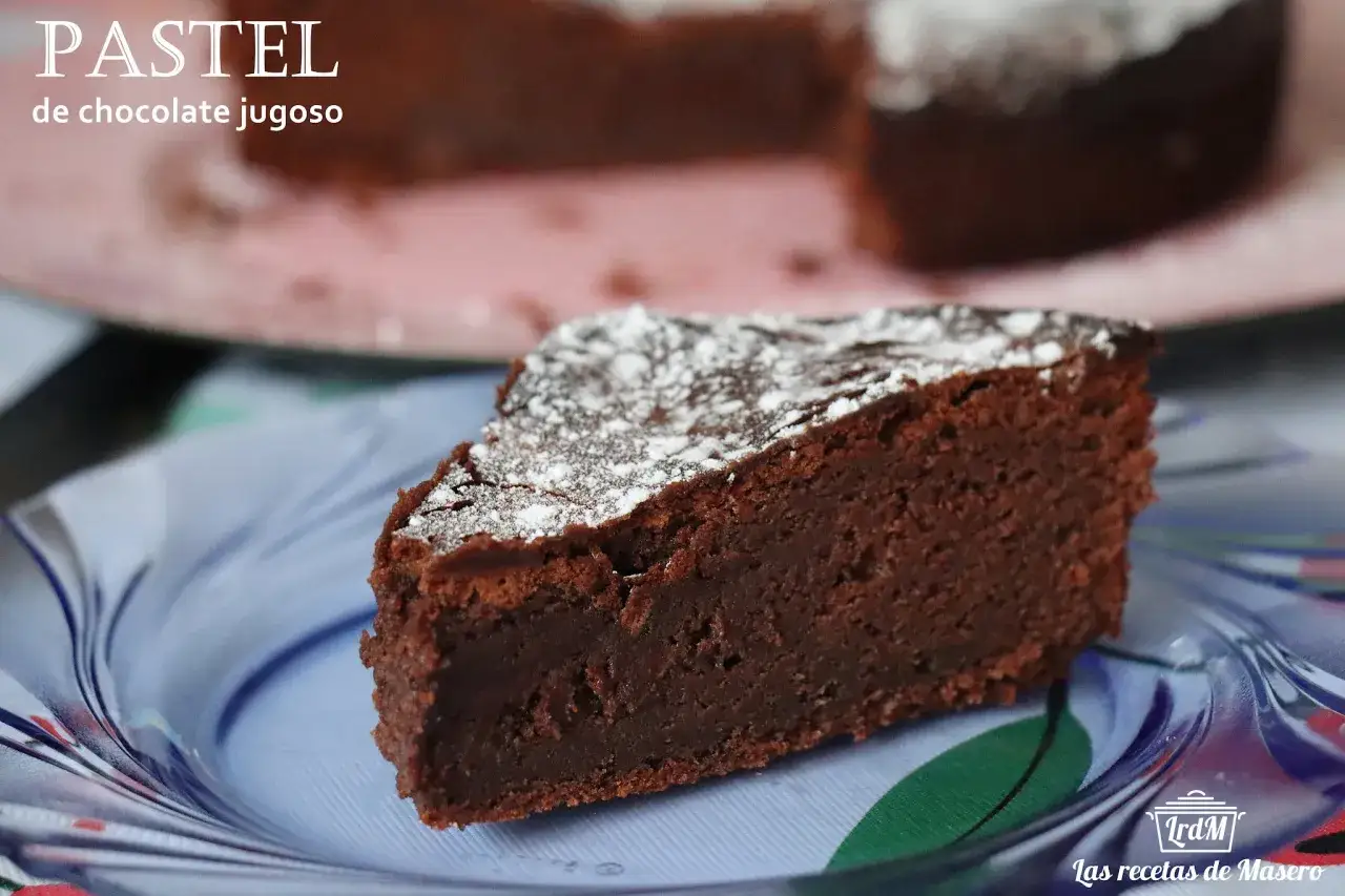 Un trozo de pastel de chocolate jugoso, espolvoreado con azúcar glas, servido en un plato azul.