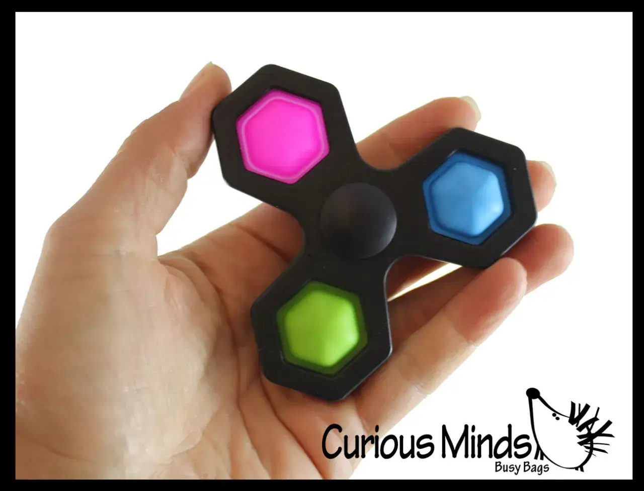 En hand håller en svart fidget spinner med rosa, blå och gröna bubblor att poppa.
