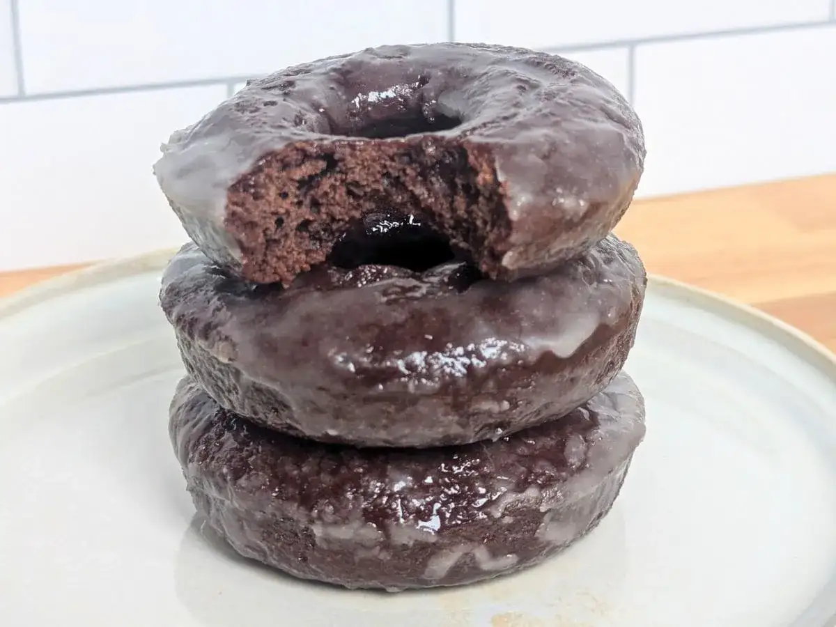 Pile de 3 donuts au chocolat glacé, un délice pour toute recette donuts.