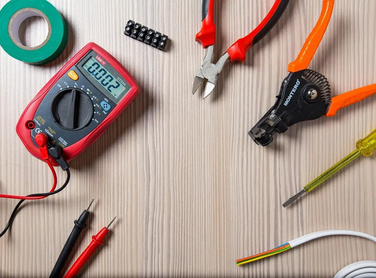 Narzędzia elektryczne: multimetr, obcinaczki, ściągacz izolacji, śrubokręt, taśma izolacyjna i przew&oacute;d. Czy to kabel aluminiowy czy miedziany?