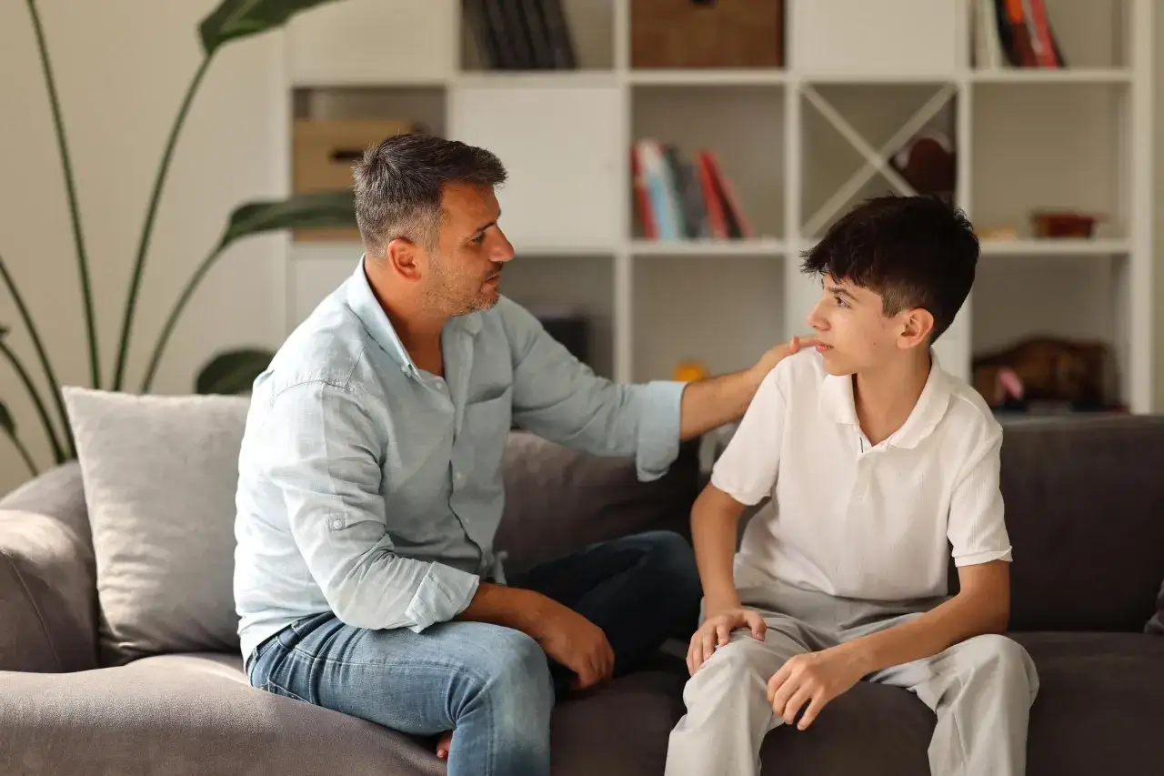 Ein Vater legt seinem Sohn tr&ouml;stend die Hand auf die Schulter. Die Sorgen um erwachsene Kinder sind oft pr&auml;sent.