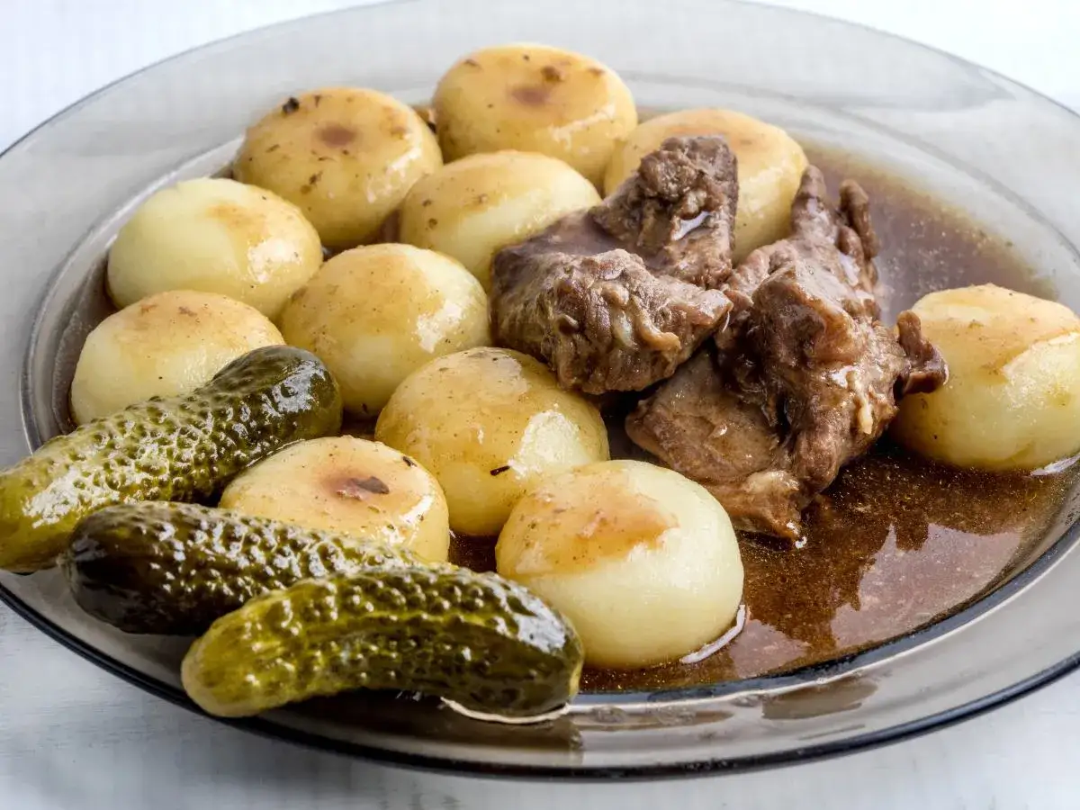Kluski śląskie z gulaszem i ogórkami kiszonymi. Gotowanie klusek śląskich jest proste, wystarczy kilka minut we wrzątku.