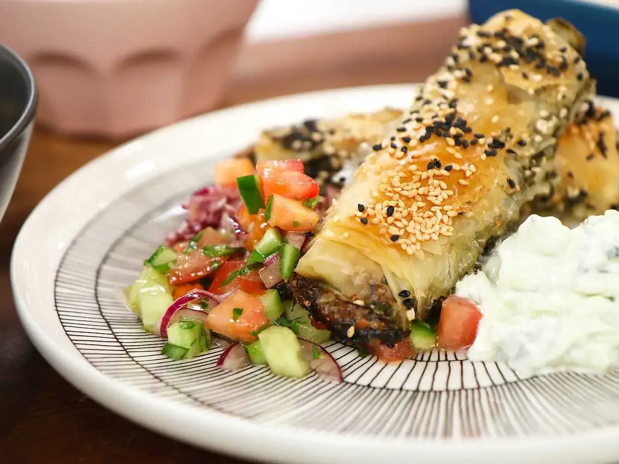 Krispiga filodegsrullar med sesamfr&ouml;n, serverade med en fr&auml;sch tomatsallad och yoghurt. Ett uts&ouml;kt burek recept!